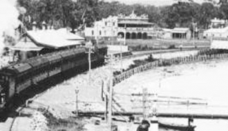 black and white photo of a train by water